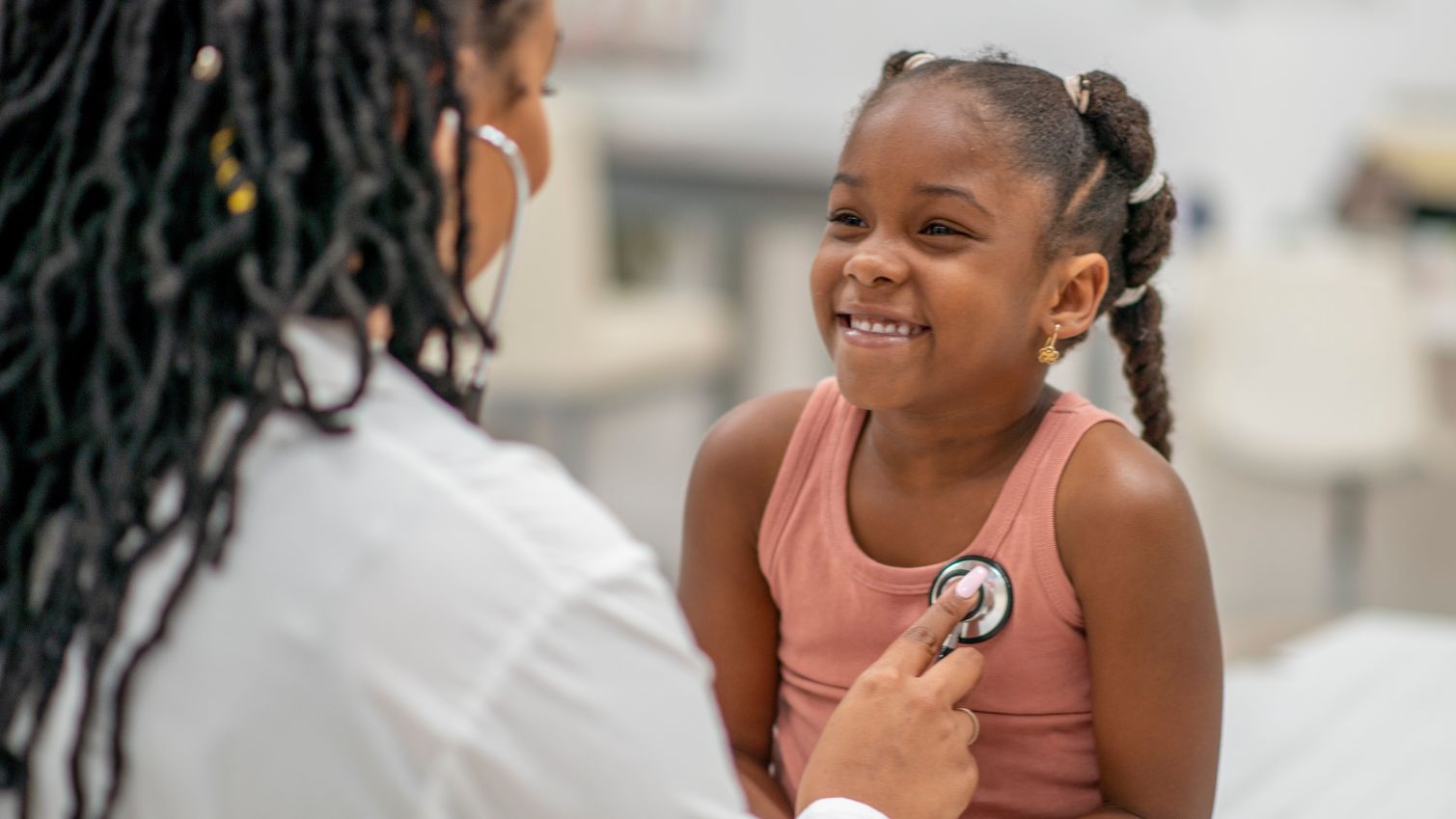 Medicaid doctor listens to girl's heartbeat